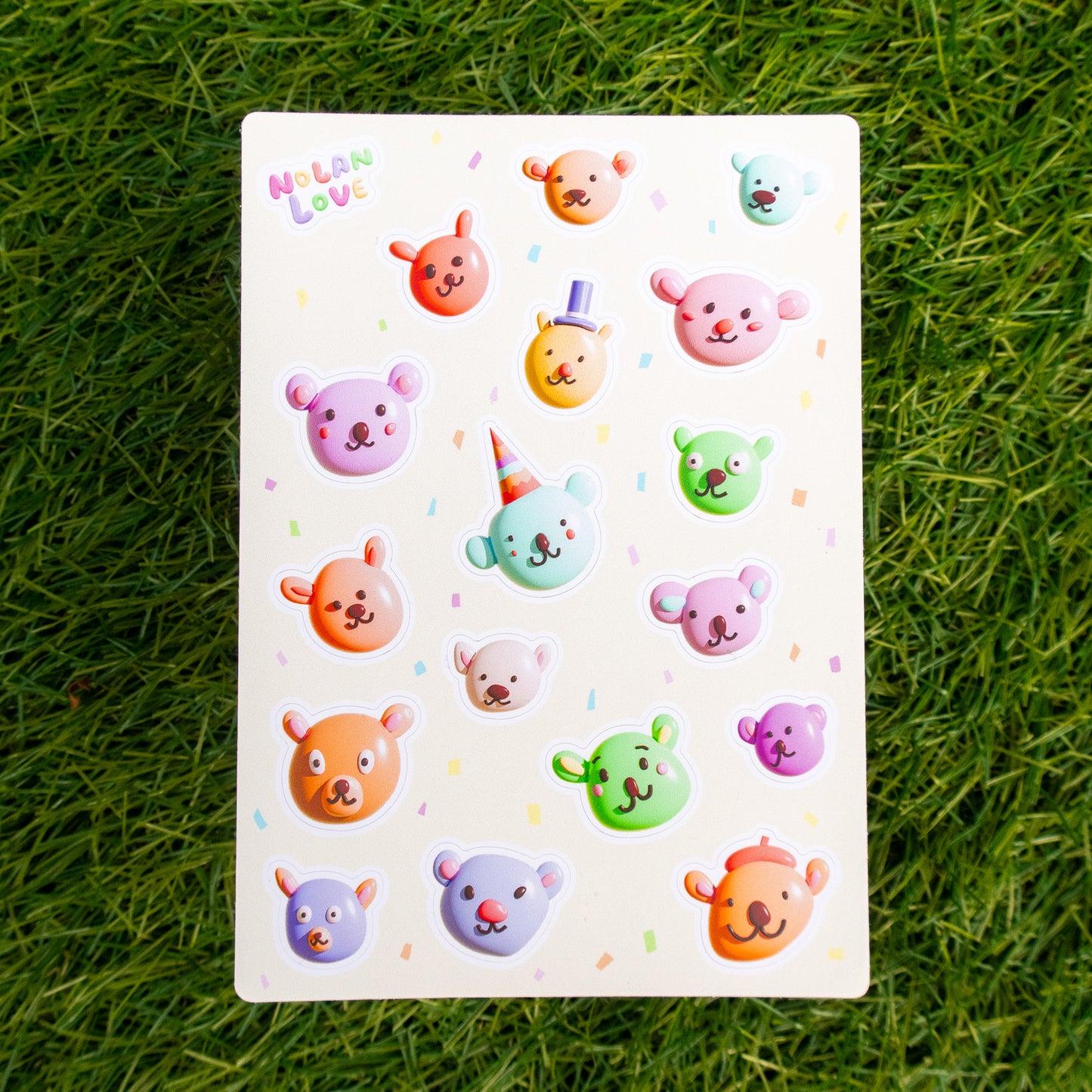 Sheet of colorful bear stickers on a grass background
