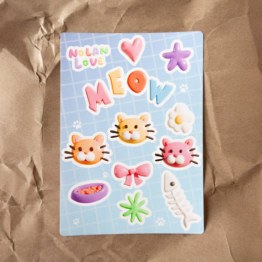 Sticker sheet with cat-themed stickers on a brown surface