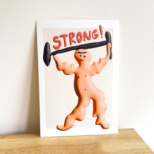 Art print with a cartoon character lifting weights and the word 'STRONG!' on a plain background.