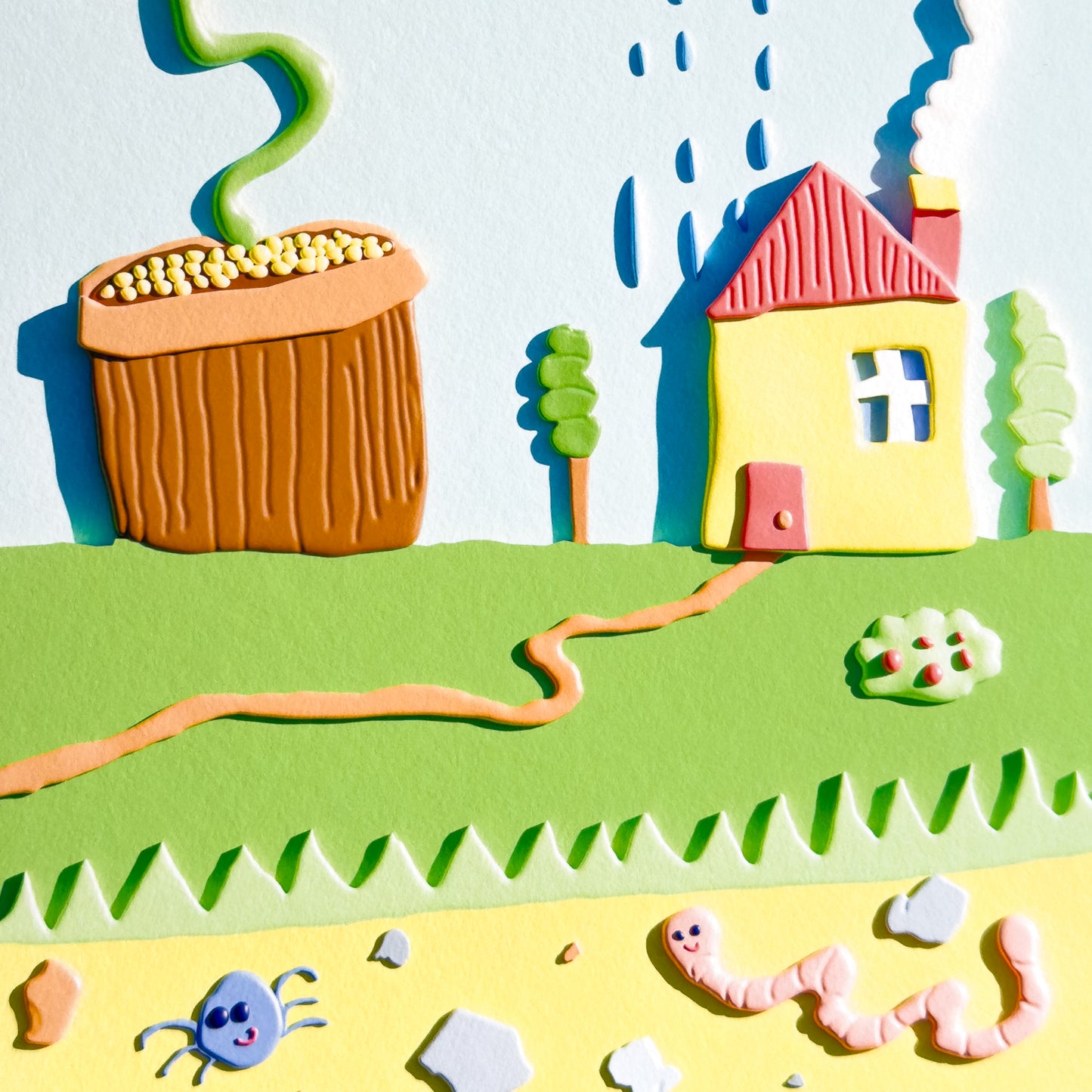 A close up of a colorful 3D giclée art print with a house, flower, and rain cloud on a white background.