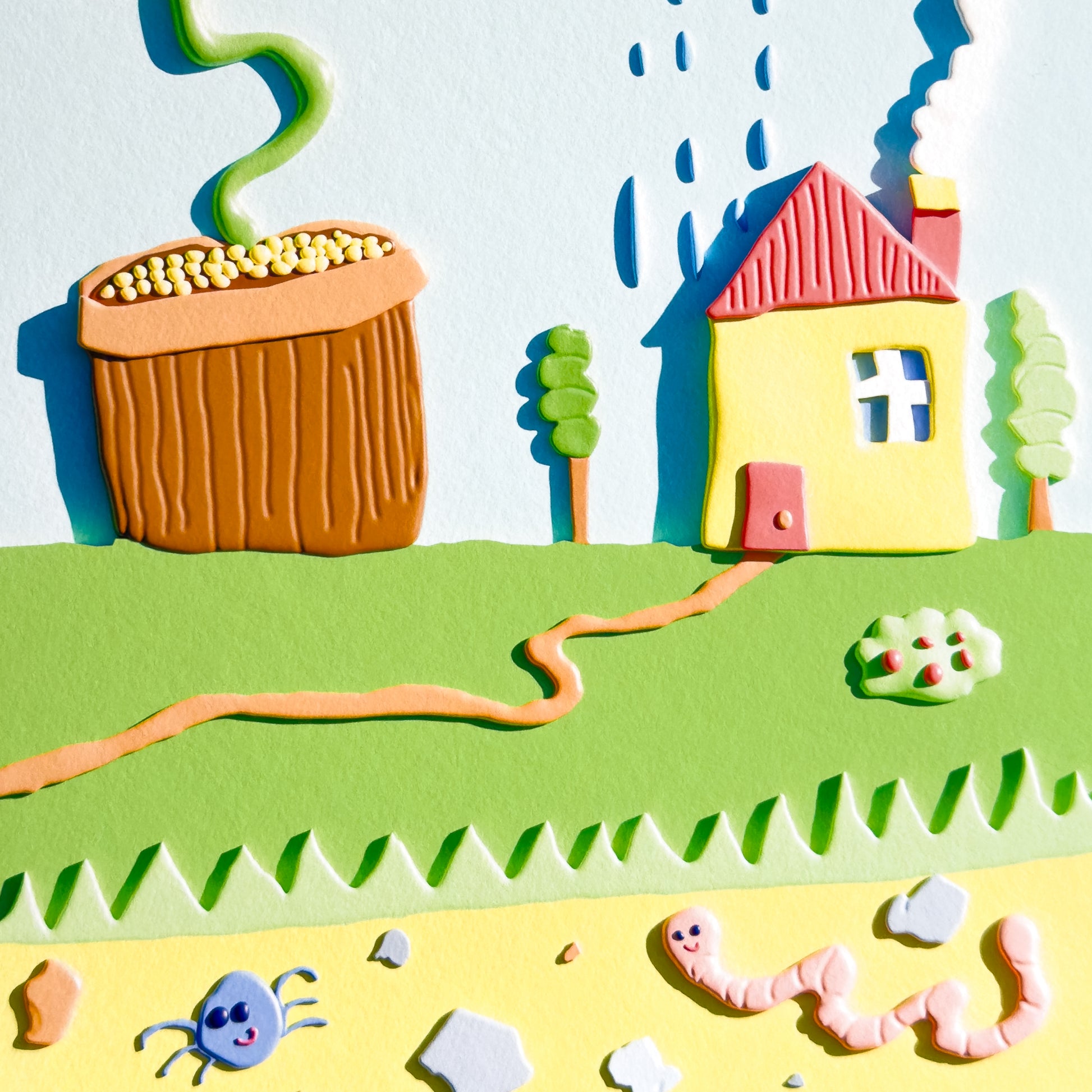 A close up of a colorful 3D giclée art print with a house, flower, and rain cloud on a white background.